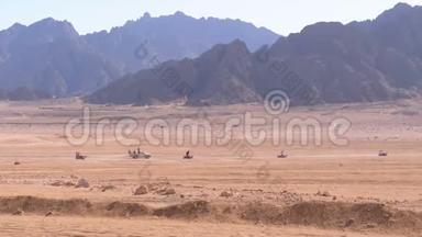 在埃及的沙漠中骑<strong>四方</strong>自行车小组，以山脉为背景。 驾驶ATV。