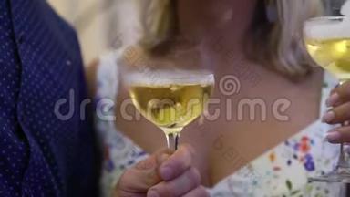 在聚会上手持一杯葡萄酒或香槟或其他酒精饮料的人。