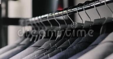 一排男式西装外套挂在衣架上。 收集新的<strong>漂亮衣服</strong>挂在商店的衣架上。