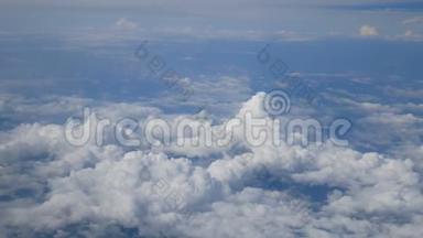 4K. 透过飞机窗户的鸟瞰。 蓝天背景下美丽的白云。 乘飞机旅行。