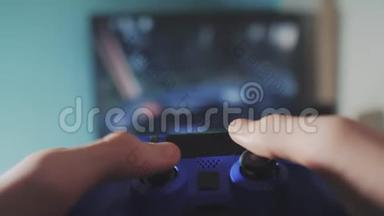 在电视上播放视频控制台。 手握新的操纵杆在线视频控制台在电视上。 玩家玩游戏游戏与游戏垫控制器