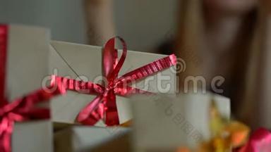 一个年轻的女人<strong>打包礼物</strong>。 现在用手工纸包裹，上面有红色和金色的丝带，供圣诞节或新年使用