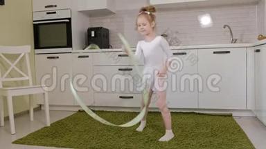 一个快乐的小女孩穿着白色体操泳衣训练，用丝带跳舞，进行艺术体操，跳跃和
