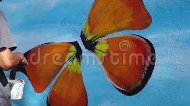 墙画家在混凝土墙上画一只蝴蝶。 时间间隔