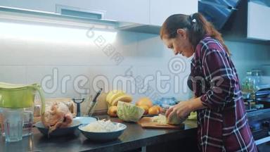 厨房里的女人准备一顿饭的生活方式概念。 厨房里的女孩用刀切卷心菜。 做素食者