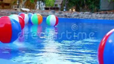 五颜六色的沙滩球漂浮在游泳池里