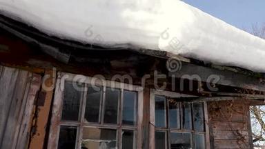 雪融化了，水滴从房子的旧屋顶滴落下来