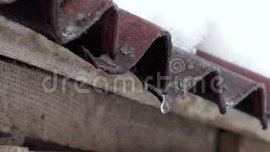 雪融化了，水滴从房子的旧屋顶滴落下来