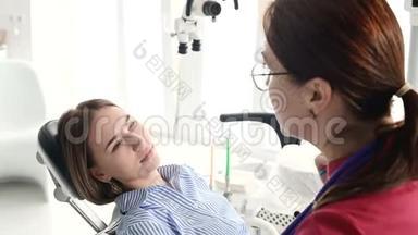 一个<strong>年轻</strong>的女孩在与一个戴眼镜的牙医女士协商时，正坐在一张椅子上的一个雄蕊学办公室。 这<strong>就是</strong>