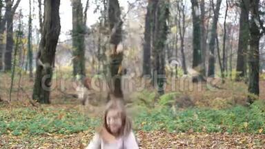 在公园里玩扔树叶和跳跃的女孩