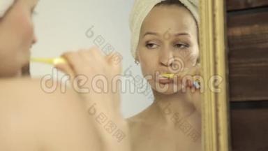 年轻的美女，头上戴毛巾，在浴室刷牙