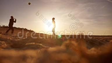 排球。 男子在沙滩剪影夕阳下打排球