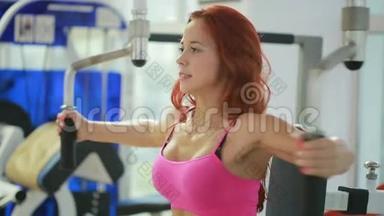 漂亮的女孩在健身房训练。