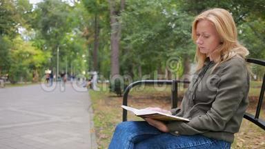 金碧<strong>辉煌</strong>的女子读书书在秋天的公园里.