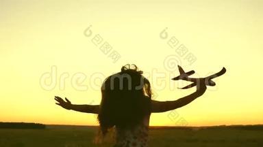 快乐<strong>的</strong>女孩带着玩具飞机在夕阳下<strong>的</strong>田野上<strong>奔跑</strong>。 孩子们玩玩具飞机。 青<strong>少年的</strong>梦想