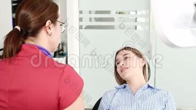 一个年轻的女孩在与一个戴眼镜的牙医女士协商时，正坐在一张椅子上的一个雄蕊学办公室。 这就是