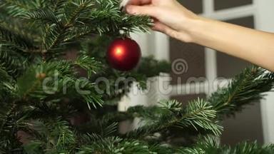 手女人用圣诞彩灯装饰圣诞树。