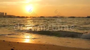 海边美丽的日落。沙滩和海浪拍打着沙滩