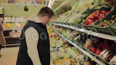 超市里的胖子自己选水果。