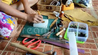 泰国妇女<strong>打孔</strong>和切割手工制作的袋皮和钥匙环皮革