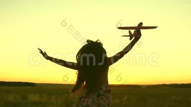 快乐的女孩带着玩具飞机<strong>在</strong>夕阳下的<strong>田野上</strong>奔跑。 孩子们玩玩具飞机。 少年梦想