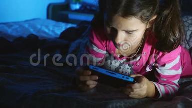 晚上在室内玩便携式<strong>电子游戏</strong>机的少年女孩