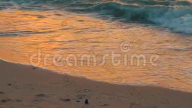 海边美丽的日落。沙滩和海浪拍打着沙滩