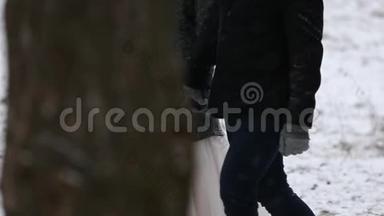 户外冬林拍摄的年轻新婚夫妇在雪天松林<strong>散步</strong>和玩得开心<strong>牵手</strong>