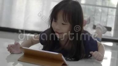 亚洲小女孩在家看数码平板电脑上的视频。