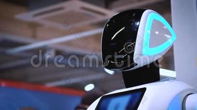新型现代白色机器人的肖像.. 机器人转过头，看着摄像机。 机器人及高科技<strong>展览</strong>