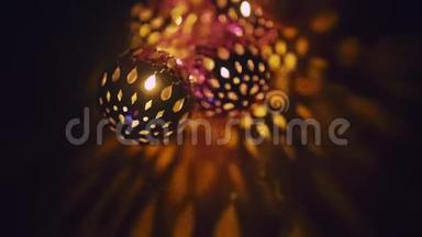 神奇的灯笼旋转，给墙壁以美丽的眩光。 双手握有发光二极管的新年发光球