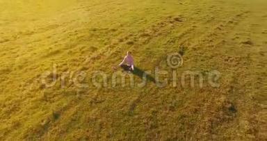 低轨道飞行围绕着绿草上的人与笔记本垫在黄色的农村田野。