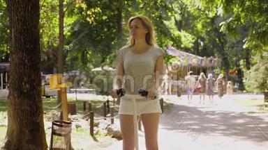 穿<strong>白色短裤</strong>的女孩，在晴朗的晴天骑着赛格威。 夏天公园和阳光。 4k，慢镜头拍摄
