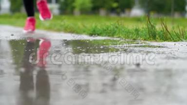 穿运动鞋的跑步者的腿。 运动女人<strong>在</strong>户外慢跑，<strong>踩在</strong>泥泞的<strong>水</strong>坑里。 单跑运动员<strong>在</strong>雨中奔跑