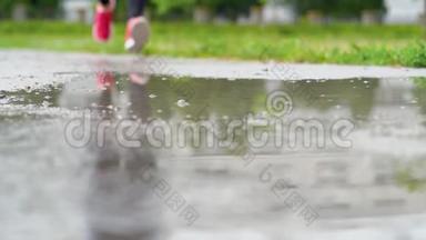 穿运动鞋的跑步者的腿。 运动女人<strong>在</strong>户外慢跑，<strong>踩在</strong>泥泞的<strong>水</strong>坑里。 单跑运动员<strong>在</strong>雨中奔跑