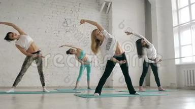 年轻女孩做瑜伽，一群人在伸展课堂上，健康的生活方式