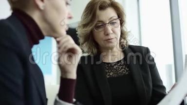 一位女经理在会议上向同事<strong>介绍</strong>新的<strong>项目</strong>计划，并向同事解释挂图上的想法