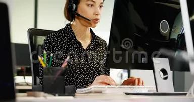 客户服务主管在桌子4k处用耳机交谈