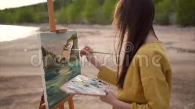 女青年画家在画架上画油画风景画