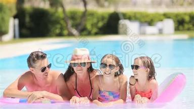 四人幸福的家庭在户外游泳池