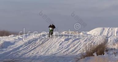 摩托车，儿童自行车骑手在雪地摩托车越野赛道。 雪上的骑士。 骑自行车的摩托车骑手，冬季骑摩托车