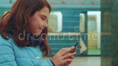 十几岁的女孩带着智能<strong>手机</strong>和耳机等待<strong>地铁</strong>，很多人聚集在地下。 地下<strong>地铁</strong>公司