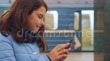 十几岁的女孩带着智能手机和耳机等待地铁，很多人聚集在<strong>地下</strong>。 地铁<strong>地下</strong>工程