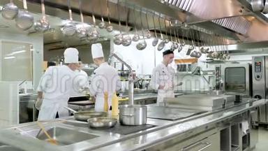 厨师在餐厅或酒店的厨房用平底锅煮蔬菜
