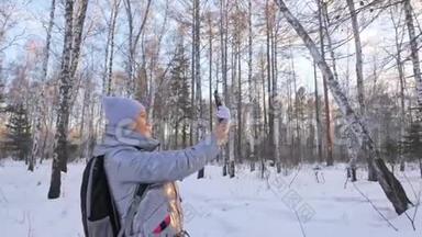 女人在树林里散步。 旅行者在森林的电话里被拍照。 女孩做自拍和沟通