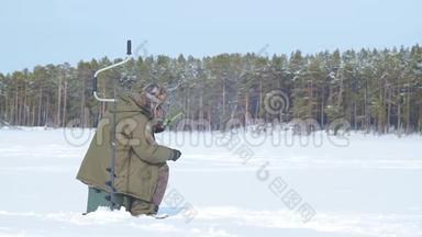 在冰冻的湖面上钓鱼的渔夫