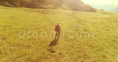 乘坐背包旅行，徒步旅行，游客步行穿过绿色的山野。 夏日的乡村山谷。
