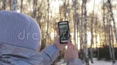女人在树林里散步。 旅行者在森林的电话里被拍照。 女孩做自拍和沟通