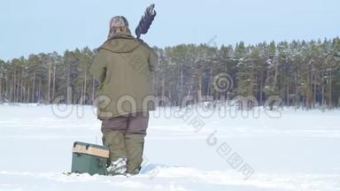 在冰冻的湖面上钓鱼的渔夫