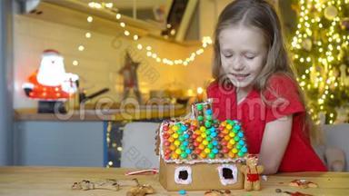 小女孩在<strong>装饰</strong>好的客厅壁炉前做圣诞<strong>姜饼屋</strong>。